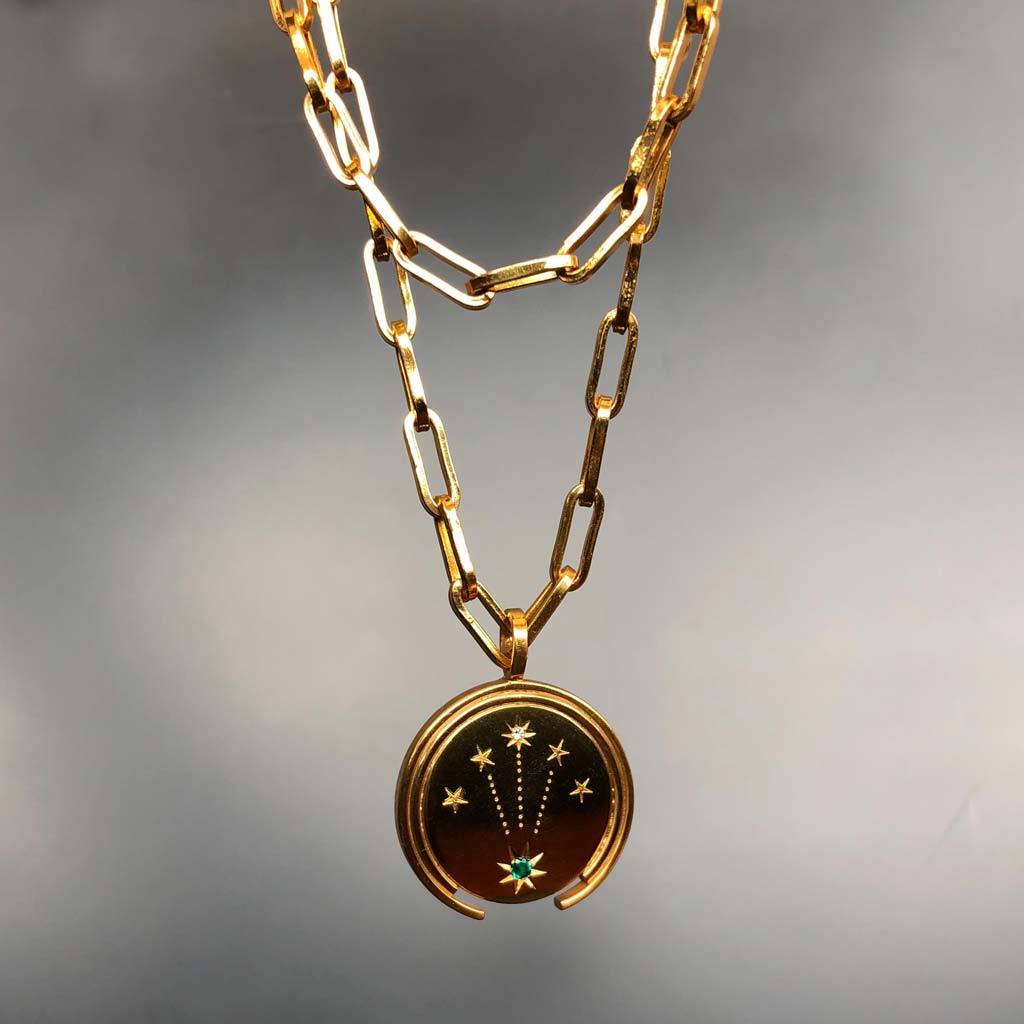 gold jewelry coin with emerald and diamond