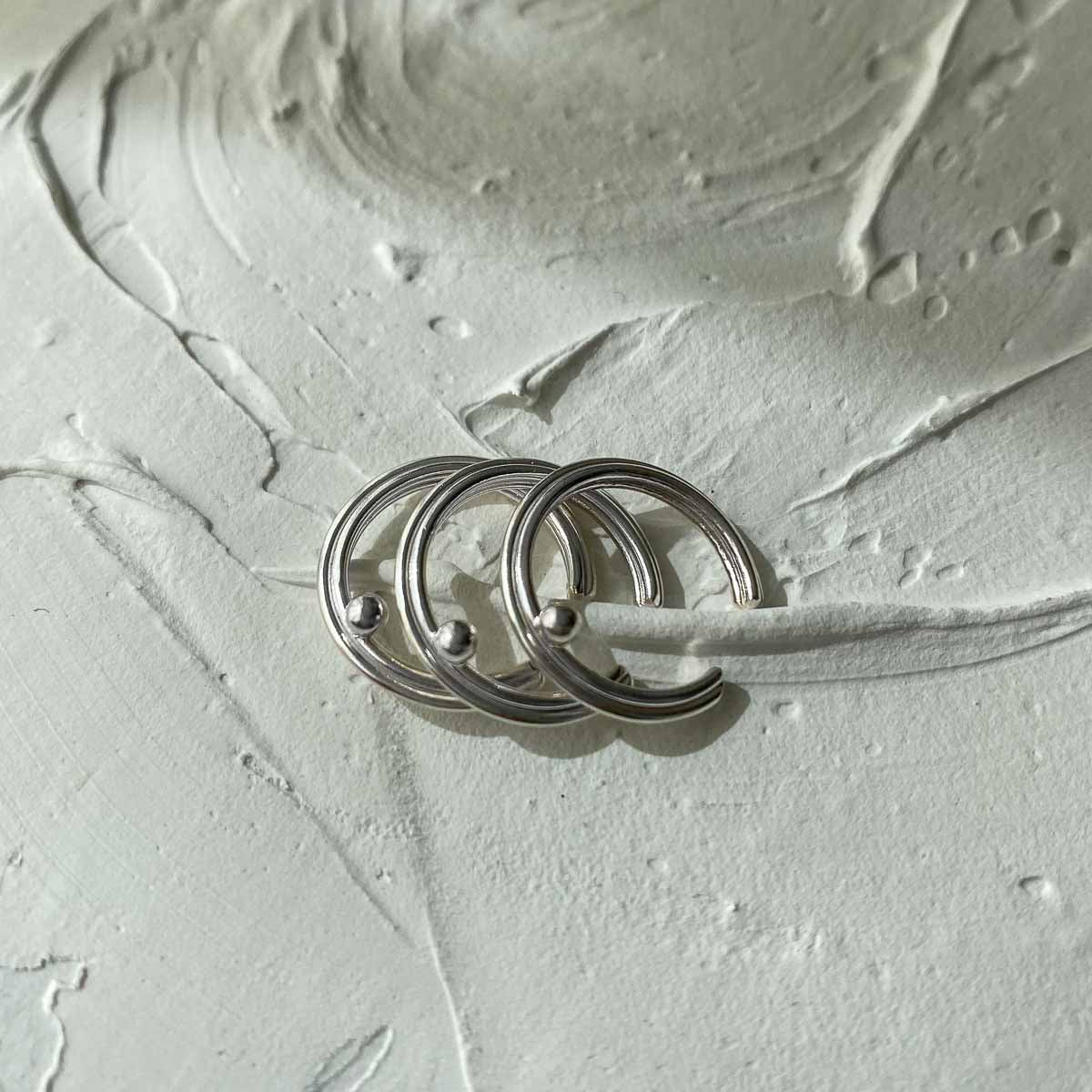 ear cuff plata lineas y esfera minimalista textura 