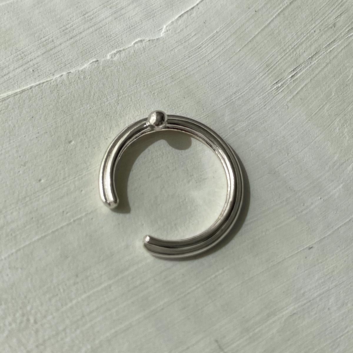 ear cuff plata lineas y esfera minimalista textura